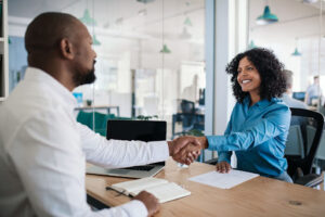 Two office employees shaking hands.