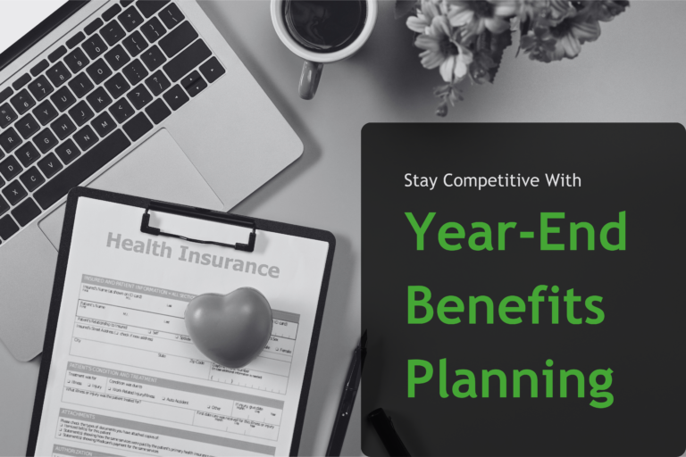 View of laptop and clipboard on desk with text overlay: "Stay Competitive With Year-End Benefits Planning"